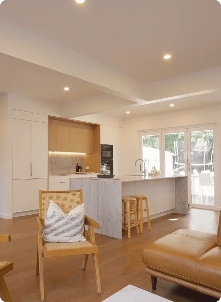 NF Build open plan kitchen and living room renovation with modern cabinetry, marble waterfall island, and timber flooring