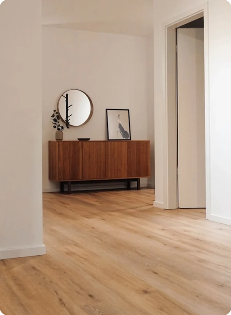 NF Build modern entryway featuring light timber flooring, round mirror, and wooden credenza side table