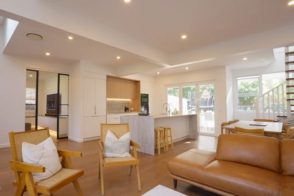 NF Build modern open plan living space with kitchen island, lounge chairs, and dining area