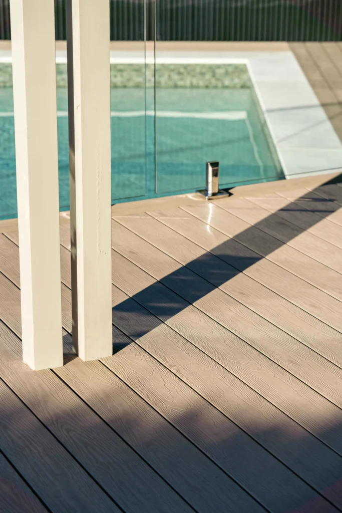 NF Build outdoor composite decking surrounding swimming pool with glass safety fence