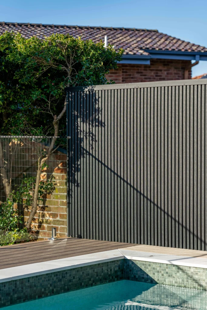 NF Build outdoor pool area with composite decking and dark grey vertical slat privacy fence