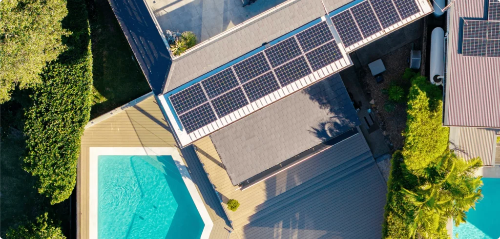 NF Build aerial view of house roof with solar panels, outdoor decking, and swimming pool